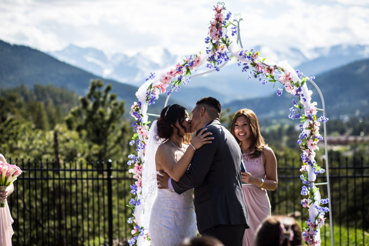 Image of newly weddings kissing at an altar at outdoor ceremony